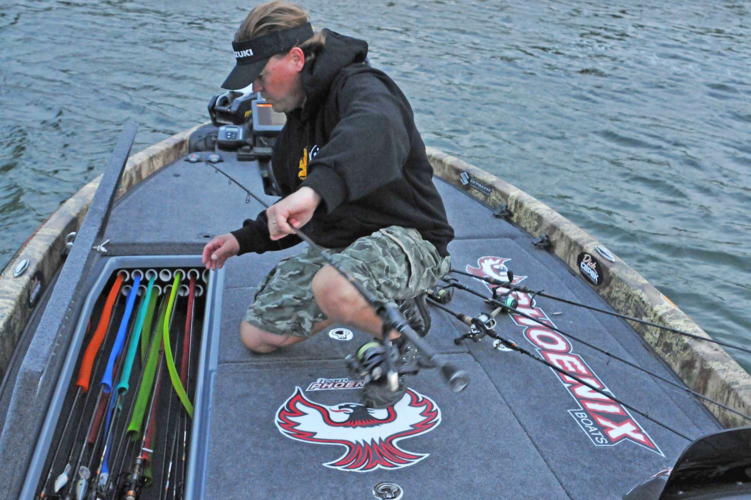 Pirch retrieves a quiver of spinning rods for the day's hunt for bass on the St. Lawrence.