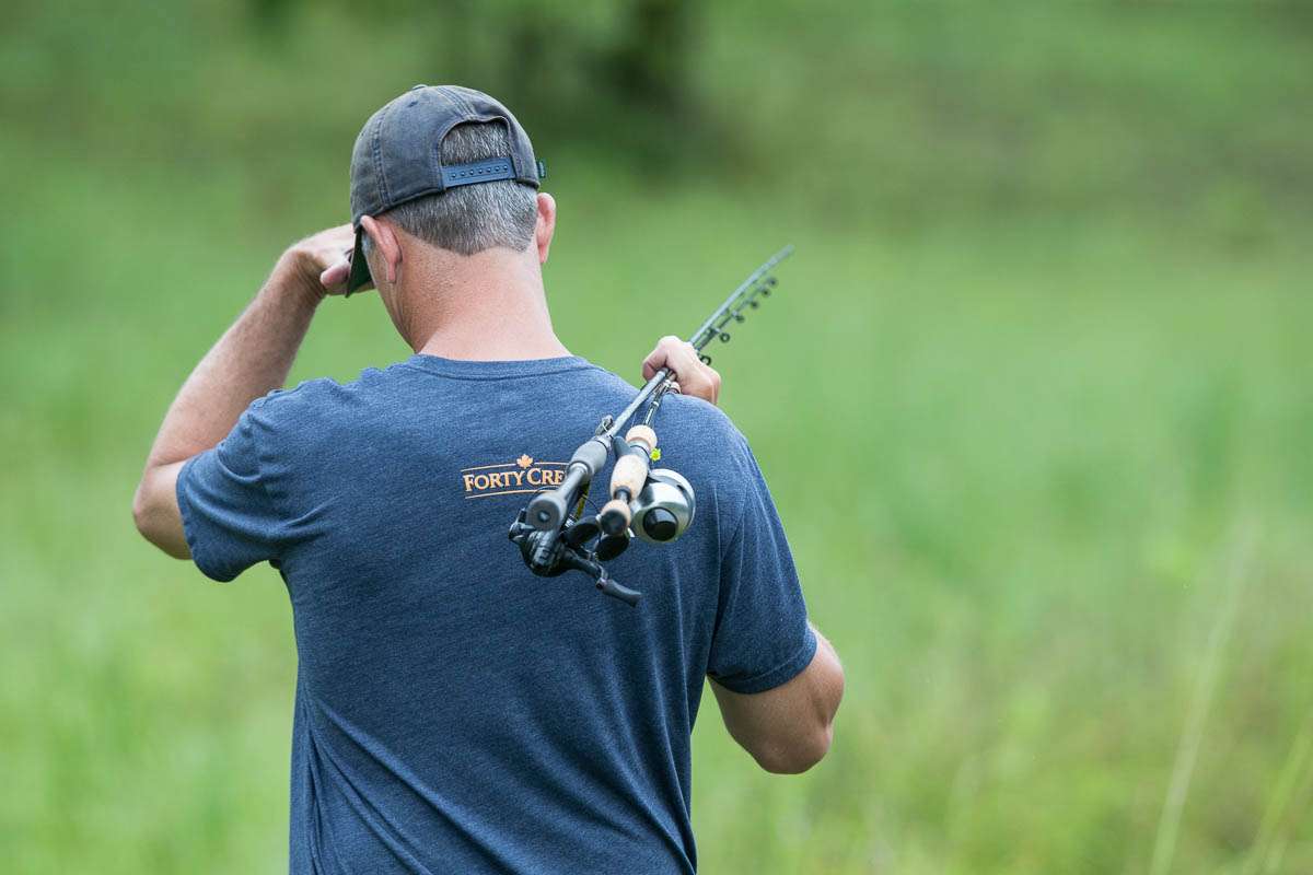 Ashley channels his inner novice angler as he walks the pond shore looking for a spot to catch a bass or two.