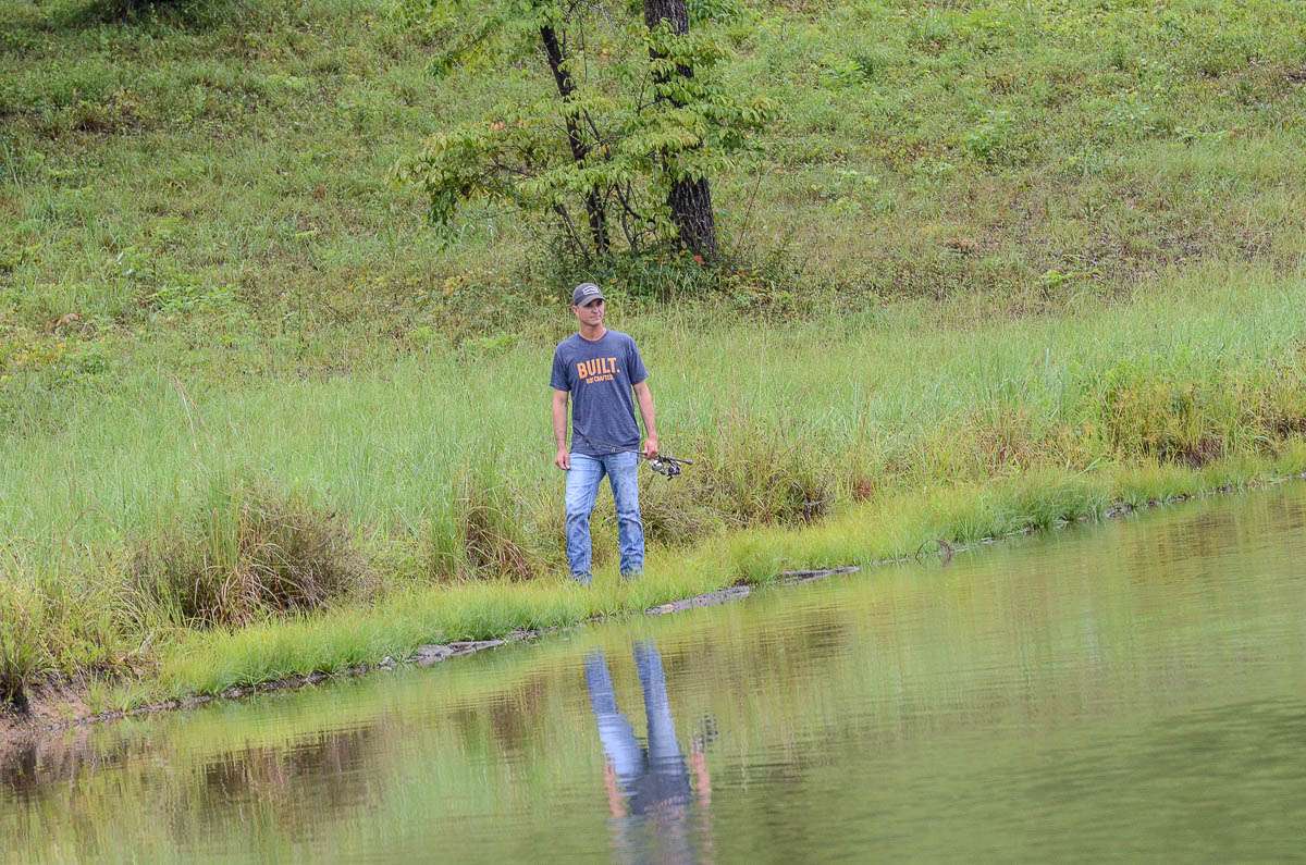 He notices fish breaking the surface in the middle of the small lake. 