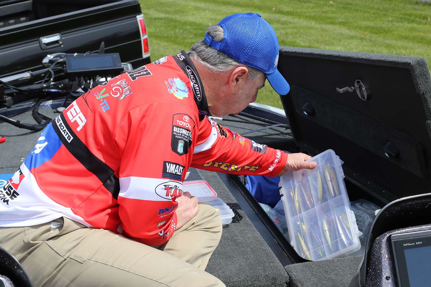 He digs deeper into a front storage compartment in his Skeeter bass boat. 