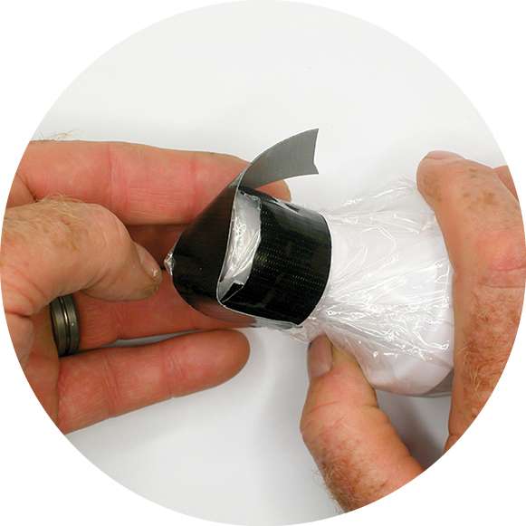 Fold and wrap the plastic bag opening around the base and tape it in place with about 5 inches of friction tape. Place a 3 1/2-inch strip across the lightâs bottom to hold your ring of tape in place when pushing the light into the pipe.
