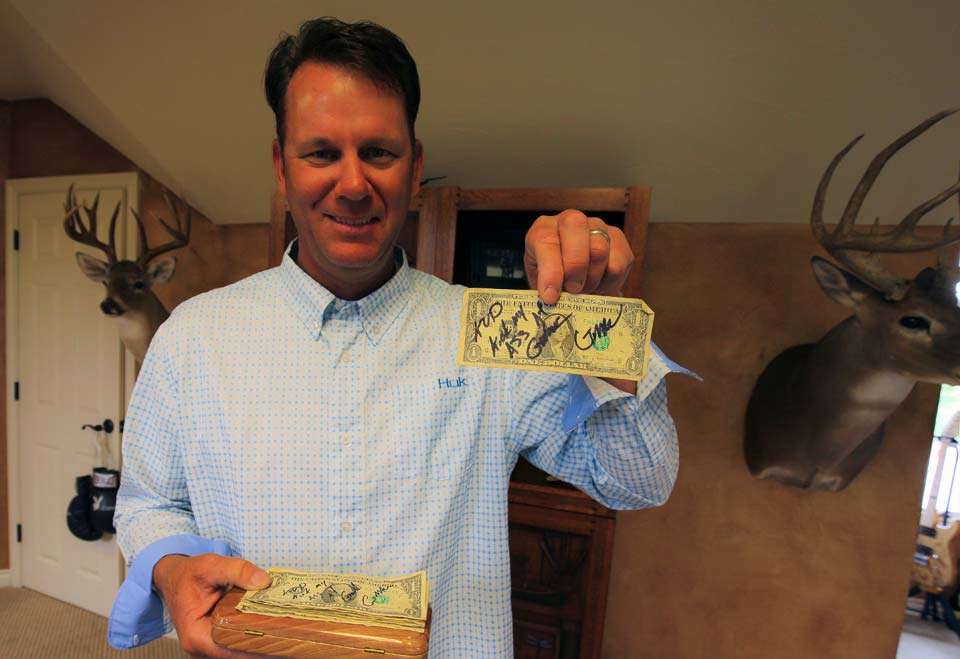 And next to it is a box filled with dollar bills all signed by Elite anglers who have lost bets to VanDam. The one heâs holding is from Gerald Swindle. 