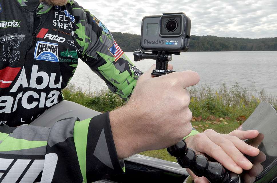 Shryock attaches a flexible GoPro handle to a GoPro base fixed securely to the windshield of his boat.
