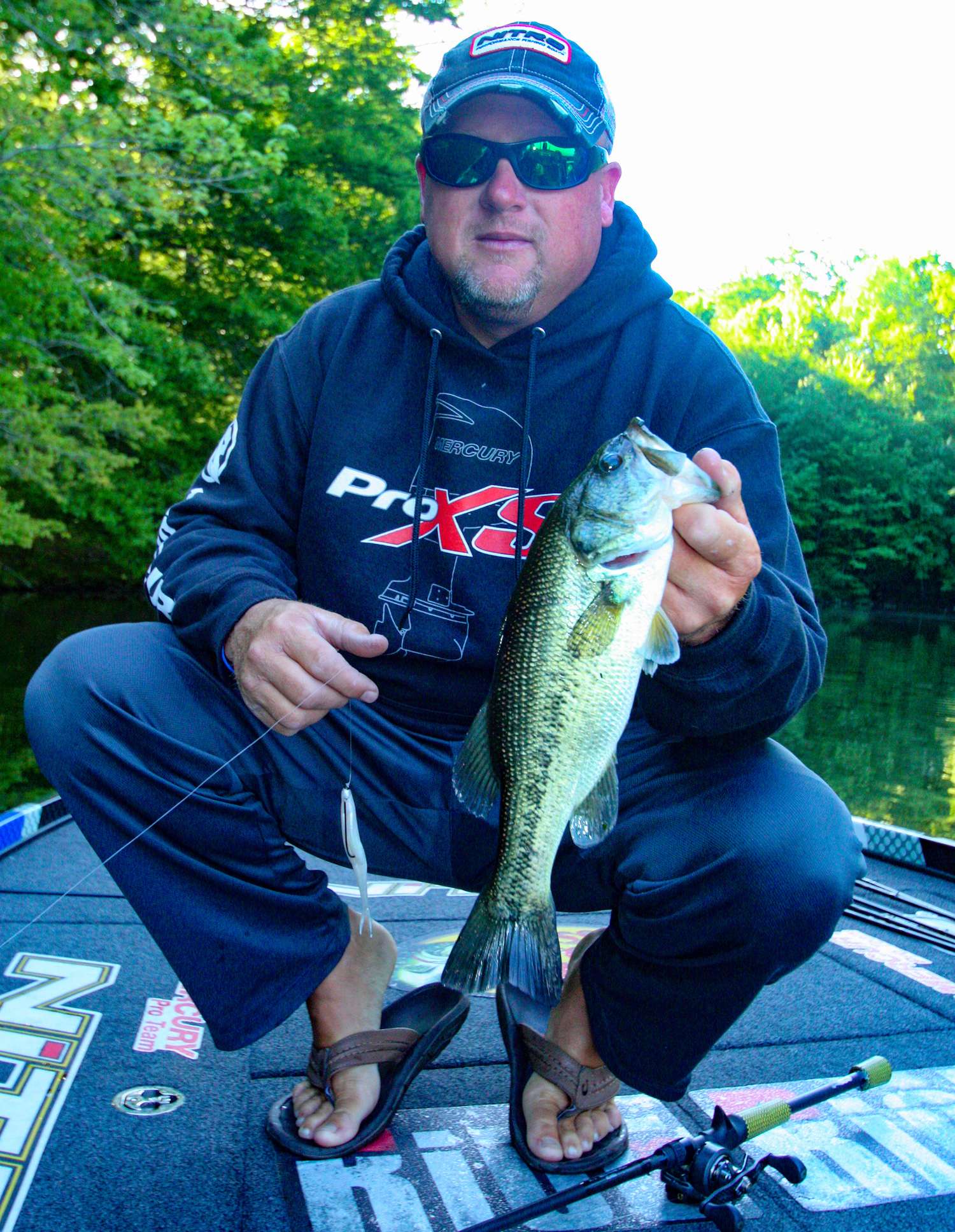 <b>8:13 a.m.</b> The creature fails to entice another fish on the dam, so Hartman switches to a pearl white Zoom Super Fluke rigged weightless with a 4/0 offset worm hook. He casts it to the bank and bags his first keeper largemouth of the day, 1 pound, 3 ounces. âI like the Fluke in calm, clear conditions. If it were windy, Iâd go with a jerkbait.â <br>
<b>8:17 a.m.</b> Pressing deeper into the cove, Hartman spots a 2-pound bass on a bed and drops his Power-Poles. âIn sight fishing, stealth is everything. Power-Poles keep your boat locked down a safe distance from the fish. Without them, you have to constantly adjust your boat position with the trolling motor, which can kick up silt and spook the bass.â He flips the brush hog onto the nest, but the fish doesnât react. âIâll make multiple presentations to different parts of the nest and watch how the fish reacts. Thereâs usually one little âsweet spotâ where an intruding lure gets the fish riled up.â <br>
<b>8:22 a.m.</b> Hartman leaves the bedding fish, vowing to check back later. He continues around the cove with the Fluke. <br>
<b>8:28 a.m.</b> As Hartman approaches a steep bank, he sees a 4-pound bass swim over the top of a submerged log. âThat fish has probably got a bed nearby.â He flips the brush hog around the blowdown. âIâm not seeing a bed yet. Iâll hit this spot again when the sun gets higher.â
