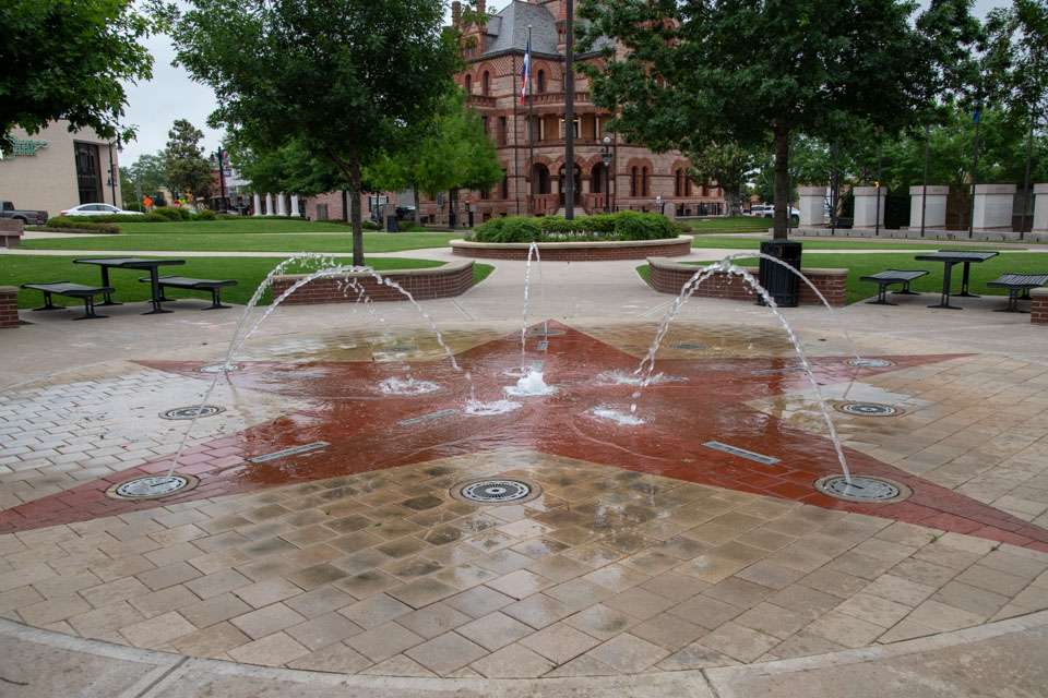 Children can splash in a water fountain located in the town square.
