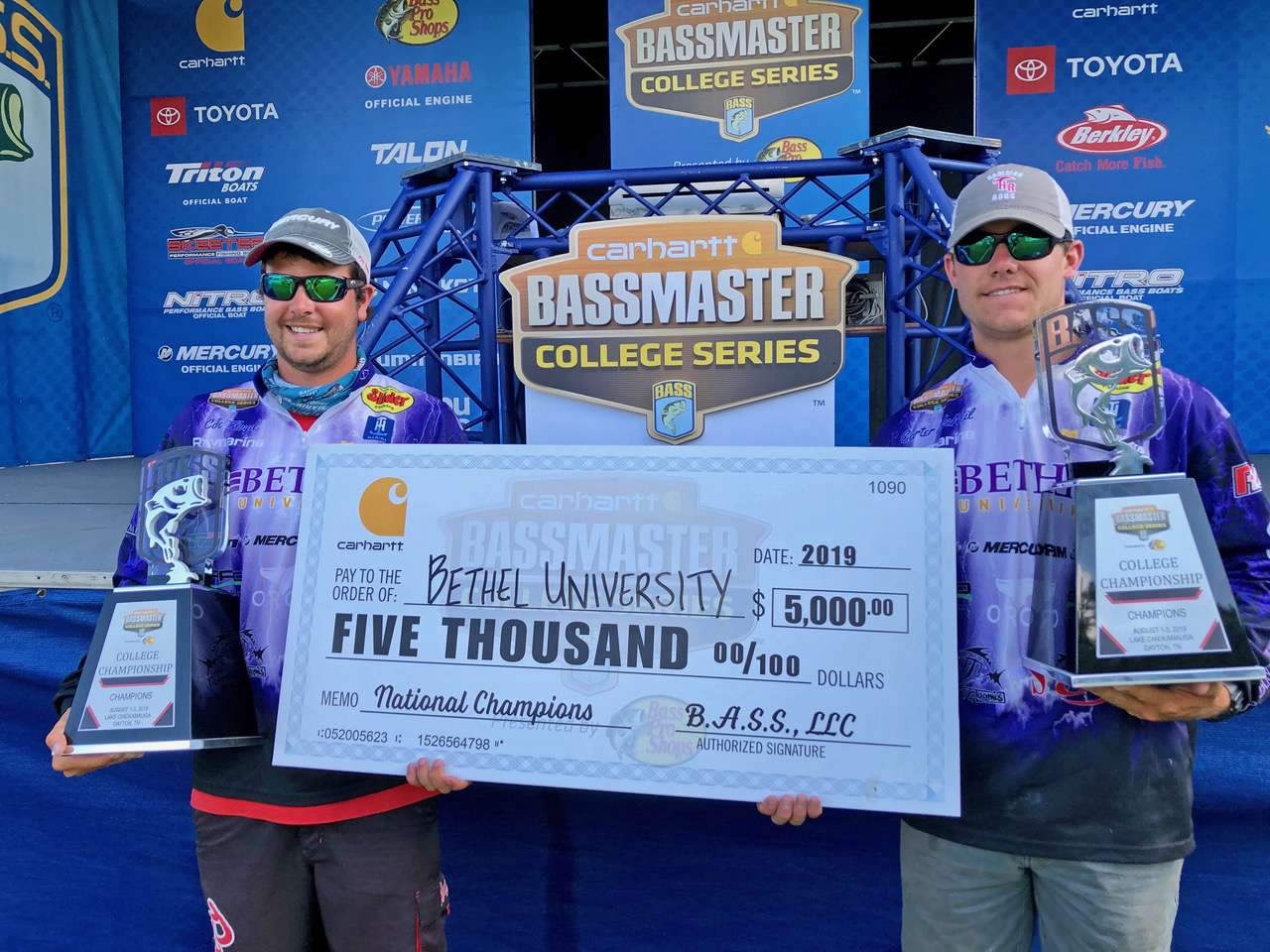 The champs pose with the winning hardware and their âHappy Gilmoreâ sized paycheck from Carhartt.