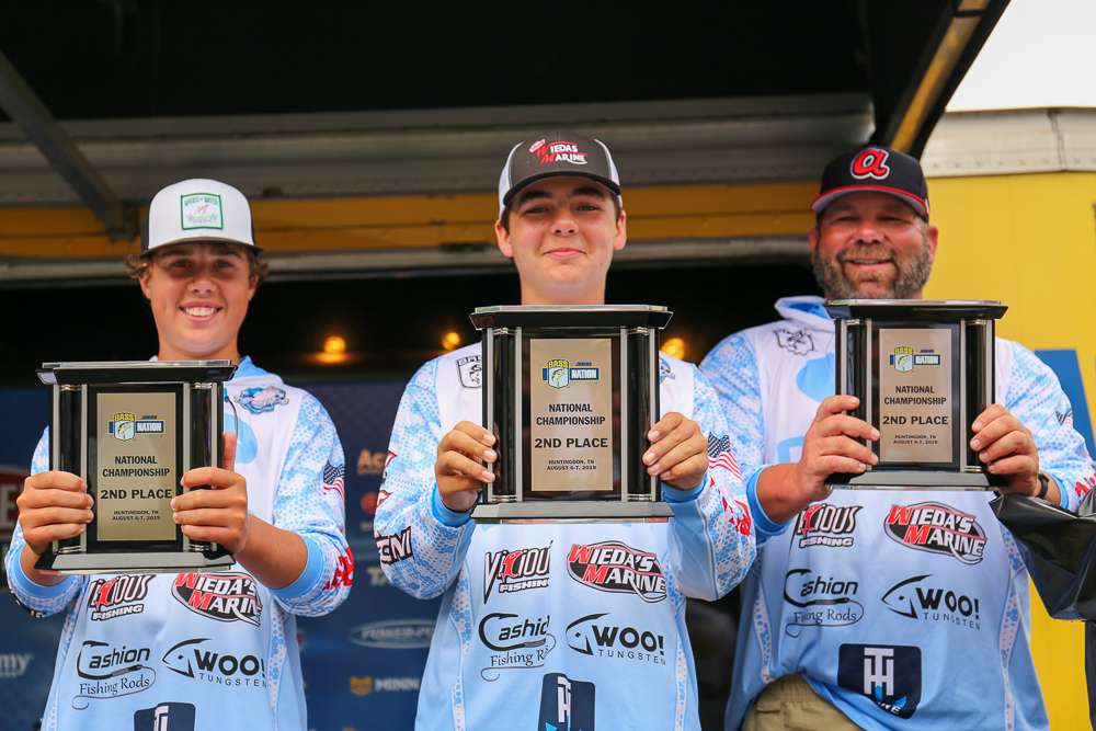 Hunter and Hayden hold up their trophies with their boat captain. 