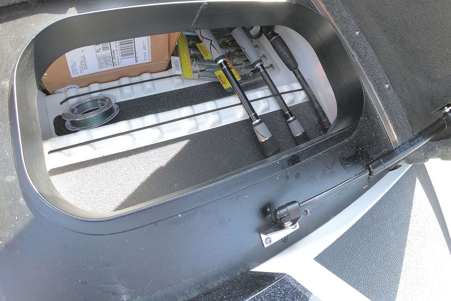 You can remove the tray from that compartment and have instant access to the rear of the driver-side rod locker. 