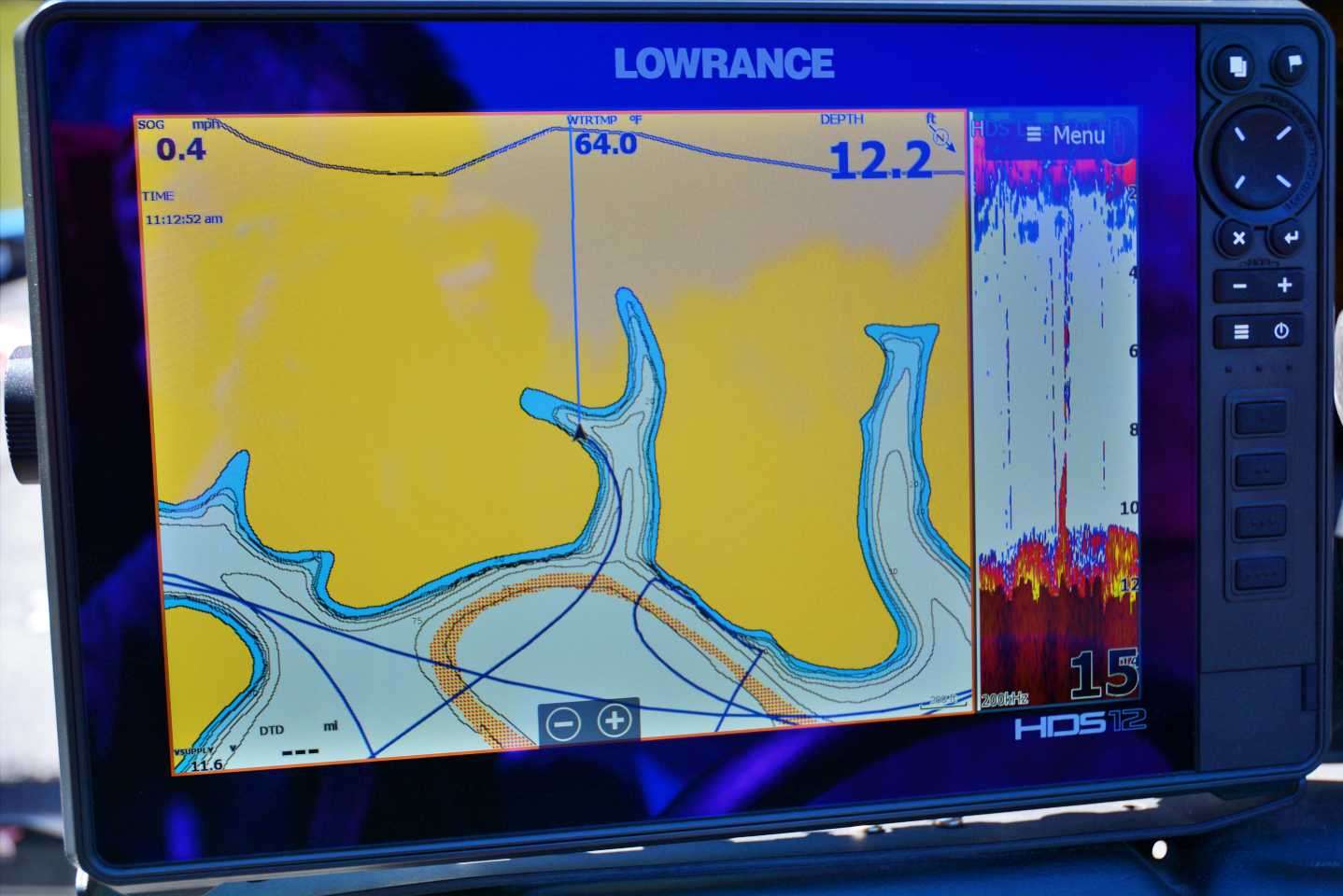 The Lowrance display illustrates a classic example of a pocket on Tims Ford. On the screen you can see his path into the pocket within the larger inundated hollow, located just off the main lake and near the river channel. Note the water temperature of 64 degrees.
