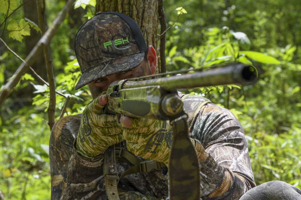Once in position, he ensures he has clear shooting lanes into the field through the cover in which he hides.