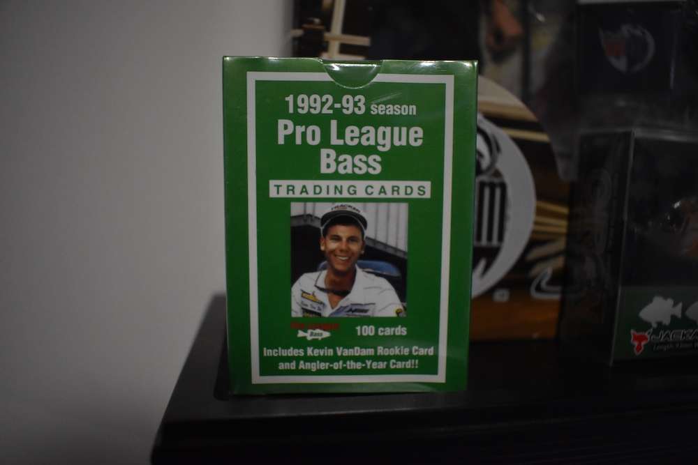 Another wall-mounted shelf has more toys and memorabilia, including this still-wrapped set of 1992-93 bass pro trading cards ...