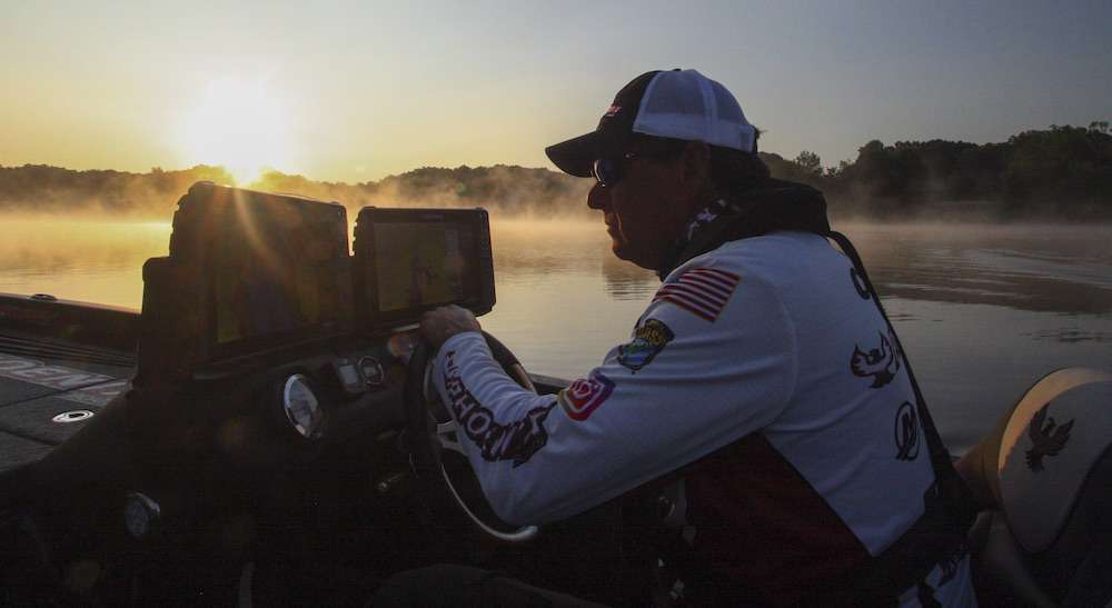 No other Elite Series sophomore can boast as much high-level tournament fishing and outdoor industry experience as Gary Clouse. The southern Missouri native was mentored in competitive bass fishing by Charlie Campbell, a legendary pro during the formative years of B.A.S.S. Clouse fished his first B.A.S.S. Invitational at Lake of the Ozarks in 1981 and eventually competed in 80 B.A.S.S. events, collecting paychecks in 28 of them. His pro fishing career was sidetracked in the â80s when he went to work for Stratos Boats in Nashville. When Stratos was sold, Clouse joined another Tennessee boat manufacturer, Triton, then eventually took over the helm at Stratos before forming his own company, Phoenix Boats, in 2007. Throughout his gigs in the bass boat manufacturing industry, Clouse somehow found time to compete in B.A.S.S. Central Open tournaments as well as in FLW and Major League Fishing events. Through it all, heâs had the dream of one day competing in the Bassmaster Classic. âItâs thrilling to finally compete full time on the Elite circuit,â he says. âIâm blessed to have a great crew keeping the boat company on course while Iâm at the tournaments.â Clouse is especially impressed by his younger Elite Series competition. âMost of these kids came up through the college circuit and their skill level is amazing,â he acknowledges. âThey already know stuff it took me 25 years to figure out. But Iâve been at this game long enough not to get easily rattled. Iâm focused on qualifying for the Classic, one bass at a time.â Stay tuned as Clouse uses this same patient approach to his advantage on Lake K on a sunny July day.
<p>
<b>6:13 a.m.</b> Itâs foggy and an unseasonably cool 56 degrees when we arrive at Lake K. Clouse pulls a stack of St. Croix rods from boat storage. What pattern does he expect will be operative today? âThis has been a hot summer, so offshore structure like points, humps and ledges should hold fish. But Iâll also hit shoreline grass and laydowns if I come across any.â
