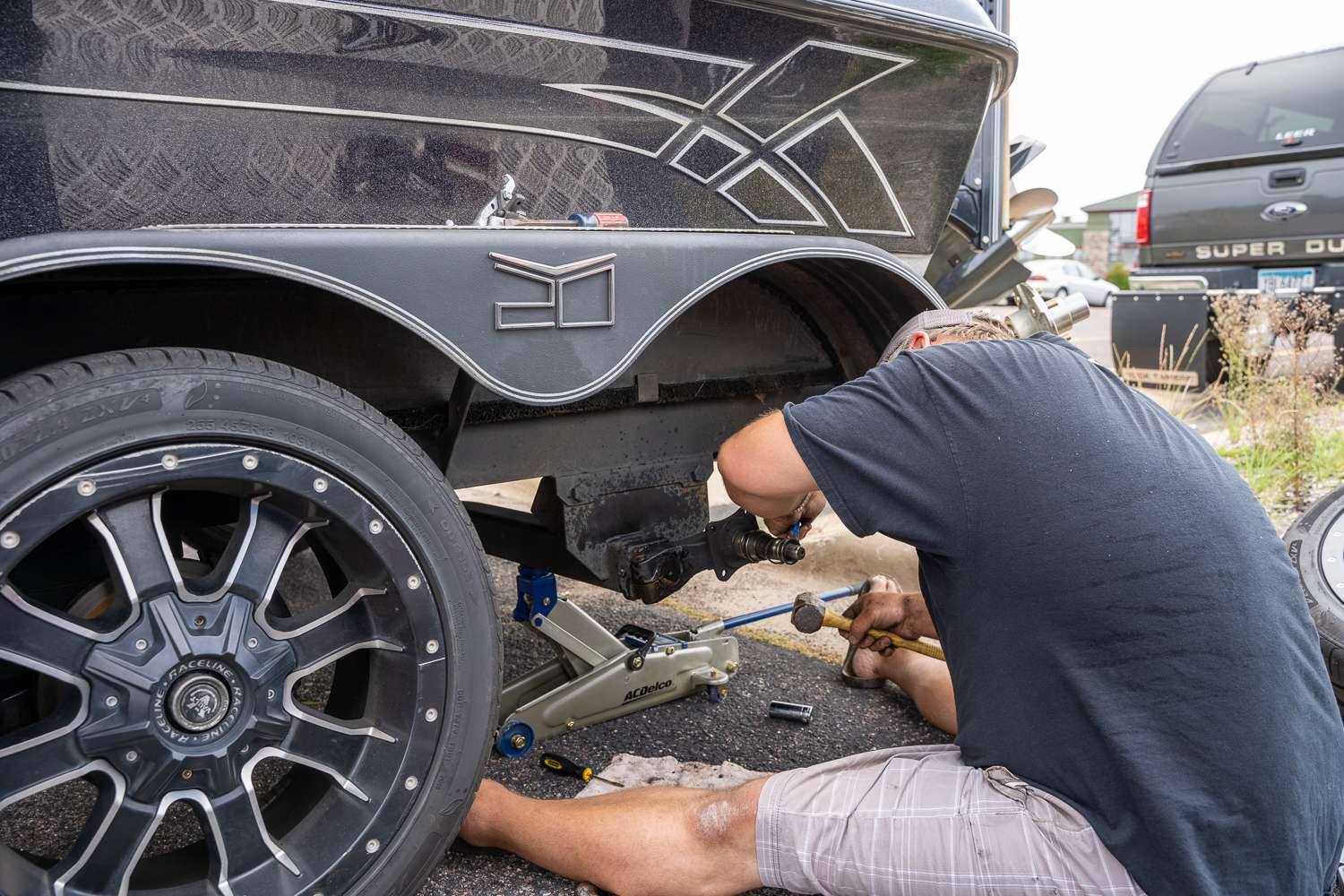 You never want to lose a trailer wheel, but at least it happened here at the hotel where angler-turned-mechanic Ryan Kriegel is busy trying to pry off the broken part. 