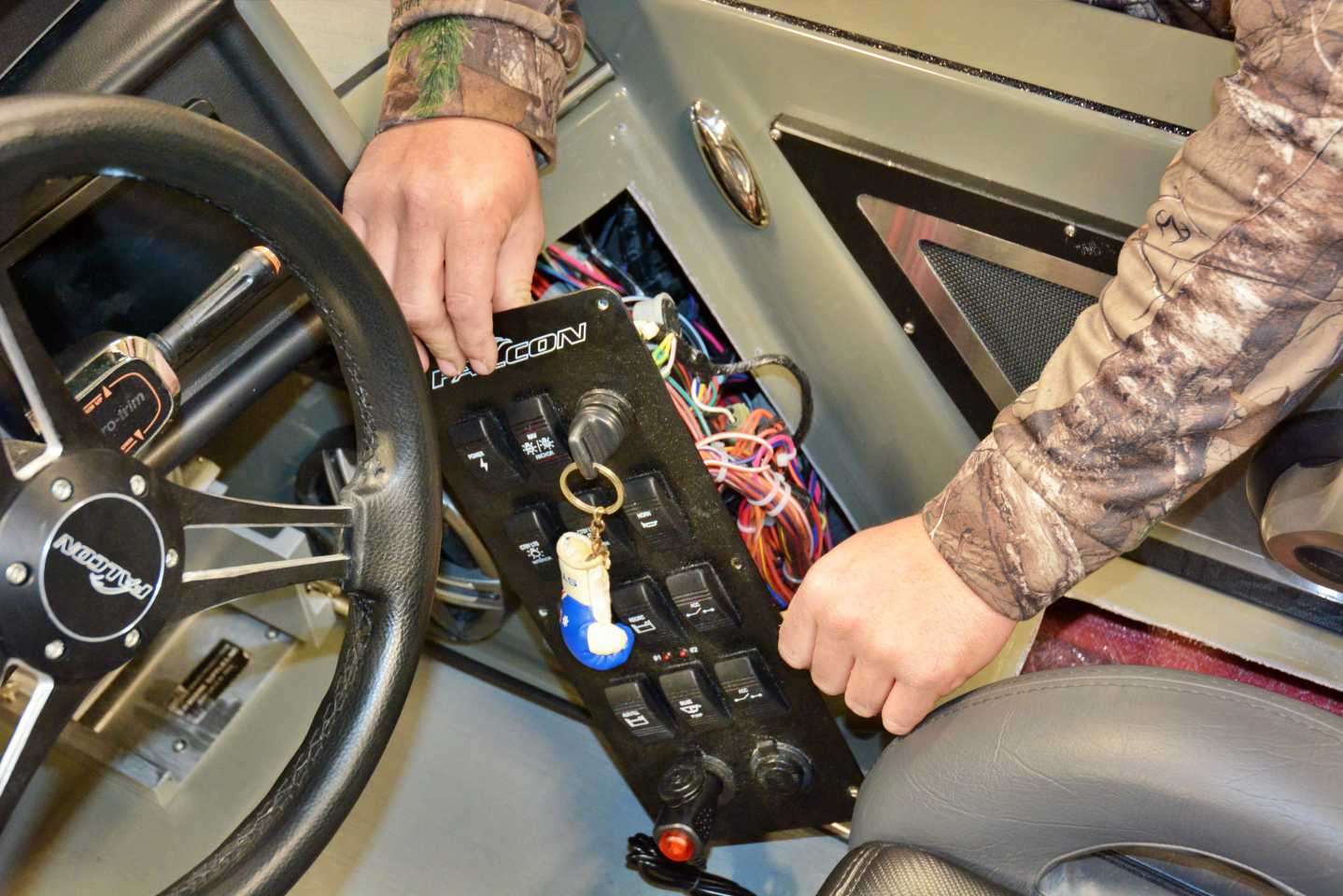 The first step when running wires through the boat is finding an access point for a wire snake. For the Falcon F20 Predator that is accomplished by removing this switch panel located below the dashboard. Doing so will allow the wire snake to reach the bow, and be pulled from the rear of the boat. 

