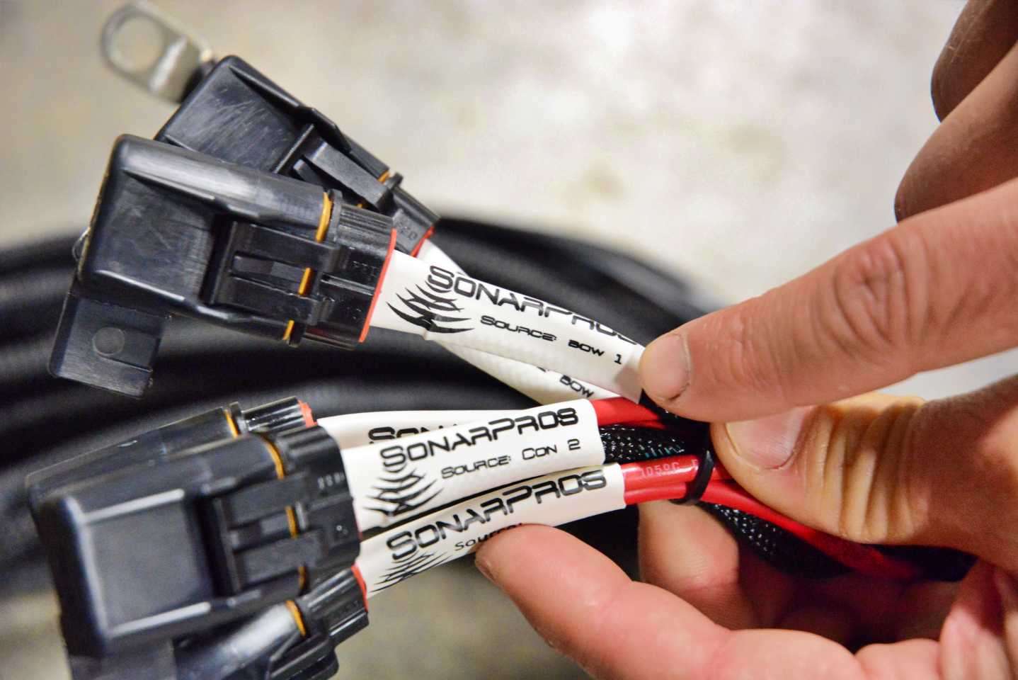 The custom-made harness has a dedicated cable for each of unit. Each plug is labeled to identify its connection location. Note the âBow 1â and âConsole 2â labels.  
