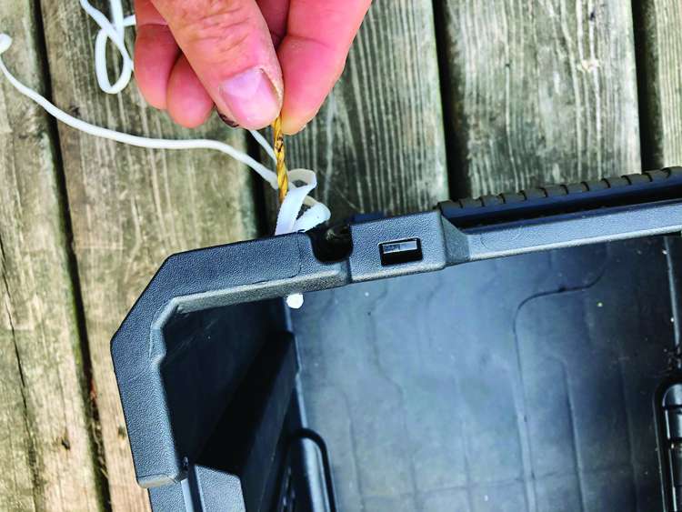 Poke the cord through with the base of a smaller drill bit.