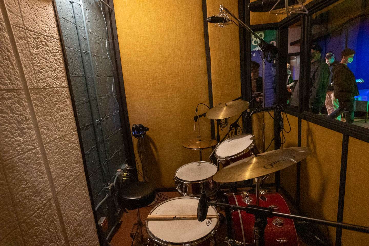 Drums have their own isolation booth, so as not to interfere with the sound picked up by the other mics. 