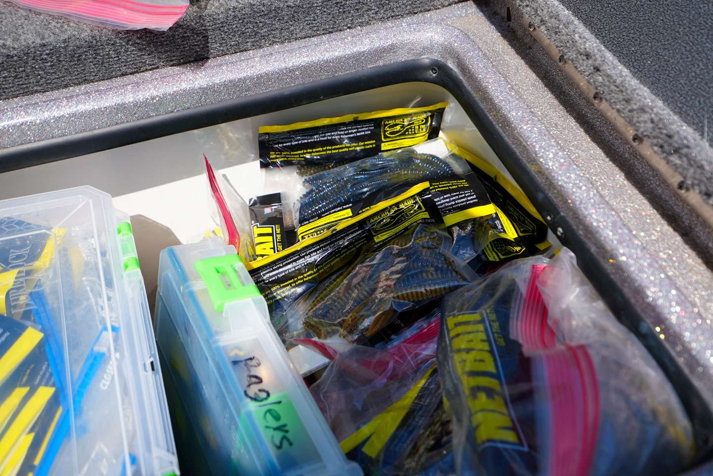A pile of Netbait soft plastics fill the top of the compartment. 