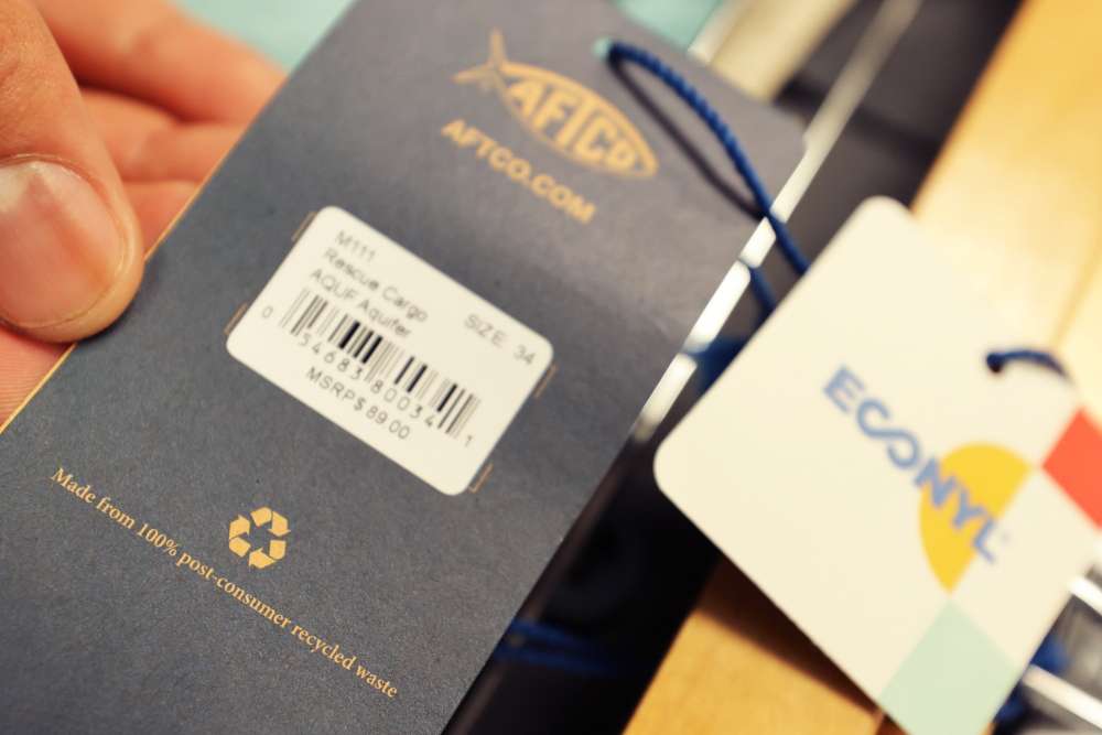 A close-up of the new AFTCO hang tag that is made from 100% post-consumer recycled waste. Another part of AFTCOâs Fisheries First Pledge is to lessen their impact on the environment. 