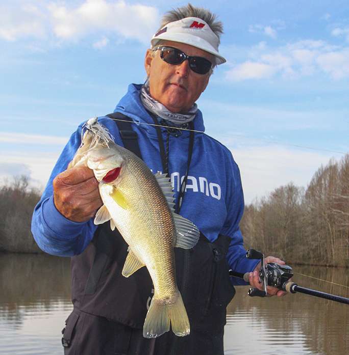 <b>8:11 a.m.</b> Schultz runs the swim jig down a big laydown and a good fish loads on. He swings aboard his first keeper of the day, a chunky 2-pound, 2-ounce largemouth. “I’d been keying on cover tighter to shore, but this fish was on a laydown farther off the bank. That’s useful input; maybe they’re staging on cover a bit farther from shore and waiting for the water to warm a few degrees before moving in tighter to spawn.” <br> <b>8:16 a.m.</b> Schultz moves farther uplake with the swim jig. His trolling motor is kicking up mud. <br> <b>8:29 a.m.</b> He moves to the back of a shallow pocket to try the swim jig in a muddy inflow. <br> <b>8:44 a.m.</b> Schultz bags a nonkeeper off an isolated stickup on the Shimano squarebill. <br> <b>8:48 a.m.</b> Schultz bangs the squarebill off a partially submerged metal pipe. “Clang! That ought to wake ’em up!” <br> <b>8:54 a.m.</b> Schultz hits an isolated brushpile with the swim jig and squarebill. No takers here, so he stashes his trolling motor and straps down his rods. “I’m going to look around the lake a little more.” <br><br> <b>5 HOURS LEFT</B><br> <b>9 a.m.</b> Schultz locates a submerged rockpile offshore and casts a brass and green Lucky Craft 2.0 squarebill around the structure. <br> <b>9:09 a.m.</b> He tries a watermelon Zoom Trick Worm rigged wacky style on the rockpile, then quickly switches to a Yamamoto Kut Tail worm in the morning dawn pattern on a drop-shot rig. ”I’m seeing a bunch of fish here on my forward-shooting electronics.”<br> <b>9:10 a.m.</b> Schultz catches a short fish on the drop-shot worm, then points to his graph: “Check it out; these fish are holding around what looks like a big tractor tire on the bottom!” <br> <b>9:19 a.m.</b> Still fishing the submerged tire. “There’s a bunch of fish down there, but they look pretty small.” He hangs the drop-shot sinker in some brush, breaks off and reties. <br> <b>9:26 a.m.</b> Schultz tries a shad pattern Rapala DT6 diving crankbait around the rockpile. <br> <b>9:34 a.m.</b> Schultz rigs a 4-inch watermelon/green pumpkin Yamamoto Senko stickworm on a 1/8-ounce shaky head and casts it repeatedly to the sunken tire.