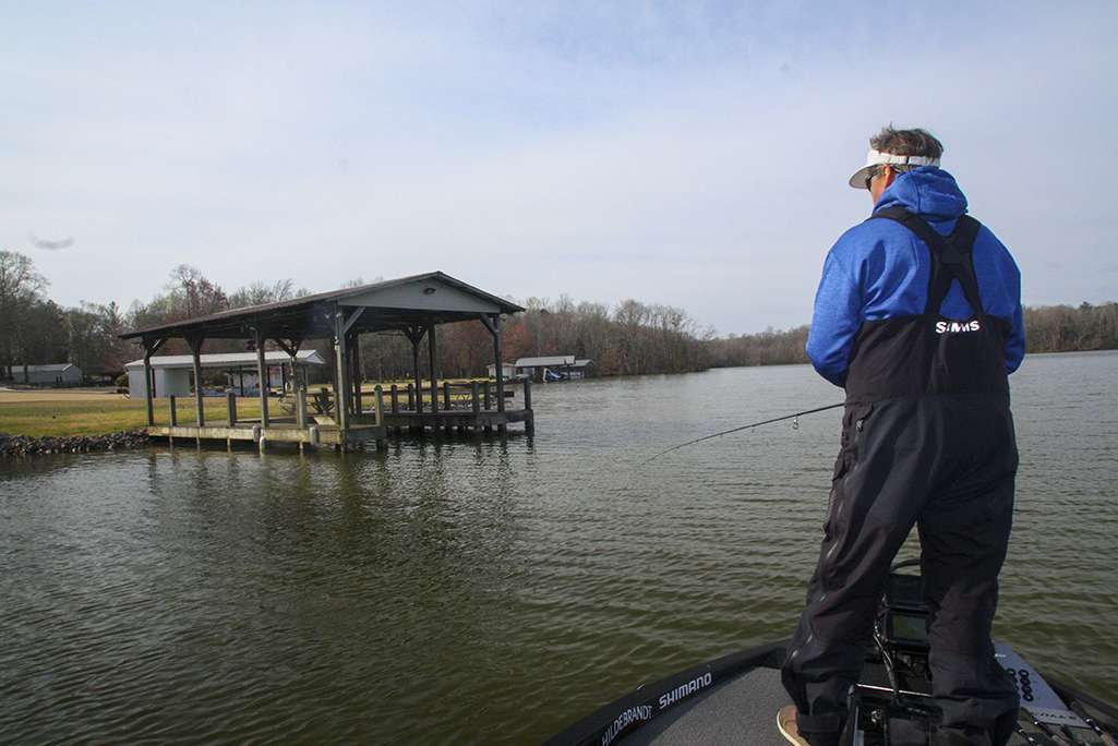 <b>9:44 a.m.</b> Schultz moves to a nearby boathouse, where he tries the shaky head worm and swim jig. <br>
<b>9:51 a.m.</b> Schultz hits another boathouse with the swim jig. “These docks are awfully shallow. Hopefully, I’ll find some with deeper water around them.”
<br><br>
<b>4 HOURS LEFT</B><br>
<b>10 a.m.</b> The row of docks ends at a shallow point. Schultz probes a big laydown extending off the structure with the swim jig, squarebill and shaky head; all three haul water. “I can’t believe I didn’t catch one there!” <br>
<b>10:09 a.m.</b> Schultz resumes cranking the point with the DT6. “I’m seeing fish here on my electronics, but I’m wondering if they’re bass.” <br>
<b>10:14 a.m.</b> Schultz rounds the point and fishes a pocket with the swim jig. <br>
<b>10:16 a.m.</b> He casts the DT6 to a submerged stump. A bass smacks it but doesn’t hook up. <br>
<b>10:18 a.m.</b> Schultz moves back to the point with the big laydown and tries both the Lucky Craft and Rapala squarebills on the structure. <br>
<b>10:22 a.m.</b> Moving back to the pocket he’d been fishing, Schultz bags a squealer on the swim jig. <br>
<b>10:26 a.m.</b> Schultz moves into a tributary arm and tries the jerkbait around submerged stumps. <br>
<b>10:28 a.m.</b> He ties on a blue and chartreuse Shimano Macbeth Flat flat-sided crankbait and casts it parallel to a shallow flat. <br>
<b>10:39 a.m.</b> Schultz tries a 3/8-ounce chartreuse and white Hildebrandt Tin Roller spinnerbait on the stump flat. “I designed this lure specifically for slow rolling; it has a tin head and blades for a slow fall, intense vibration and realistic flash.” He catches a short fish on his first cast with the spinnerbait. <br>
<b>10:44 a.m.</b> Schultz upgrades to a 1/2-ounce Tin Roller, “so I can hit those deeper stumps.” <br>
<b>10:56 a.m.</b> Schultz can’t stand not trying the spinnerbait on the laydown point, so he zips back there, slow rolls it through the branches and gets a hard strike — but the fish doesn’t hook up! 
<br><br>
<b>3 HOURS LEFT</B><br>
<b>11:13 a.m.</b> Schultz finally abandons the point and runs back to a flat he fished earlier with the swimbait. He now combs the structure with the Tin Roller. <br>
<b>11:18 a.m.</b> The wind is gusting 15 mph out of the southeast as Schultz tries the swim jig again on the flat. “The water’s dirtier here than on that stump flat. Maybe they’ll slide up shallower on this bank.” <br>
<b>11:23 a.m.</b> The wind is blowing straight onto the flat, prompting Schultz to go back to the Tin Roller. “Spinnerbaits work best in windy conditions — the rougher, the better. Chop on the surface diffuses the flash, so the blades look like a school of fleeing baitfish.” <br>
<b>11:30 a.m.</b> Schultz tries a chrome and gold Rapala Rippin’ Rap lipless crankbait on the flat. <br>
<b>11:47 a.m.</b> Schultz comes to a series of shoreline pockets and pounds them with the swim jig, wacky worm and spinnerbait. No luck, however.
<br><br>
<b>2 HOURS LEFT</B><br> Schultz has his trolling motor on high while burning the Rippin’ Rap around uplake flats and pockets. <br>
<b>12:14 p.m.</b> Schultz has reached a point studded with submerged stumps and laydowns at the mouth of a feeder creek. He works the juicy-looking structure over with the spinnerbait, swim jig and shaky head without success. “This looks like the best dang spot on the entire lake, but appearances can be deceiving. I’m starting to think the bass in this lake just don’t like cover!” <br>
<b>12:22 p.m.</b> Schultz ties on a 1/2-ounce green pumpkin/orange jig (brand unknown), adds a matching Yamamoto Fat Baby Craw trailer and flips it into the laydown. <br>
<b>12:30 p.m.</b> Schultz enters the creek adjacent to the point and alternates between the flipping jig and jerkbait. <br>
<b>12:44 p.m.</b> He retrieves the ChatterBait down a big, submerged log. <br>
<b>12:55 p.m.</b> Schultz has reached the extreme back end of the tributary. He tries the swim jig and lipless crank here but can’t coax a strike. 
<br><br>
<b>1 HOUR LEFT</b><br>
<b>1 p.m.</b> Schultz vacates the creek, then hits two boathouses near its entrance with the DT6 and jerkbait. <br>
<b>1:15 p.m.</b> A bass “knocks the crap” out of Schultz’s jerkbait near a boathouse, again without hooking up! “As sharp as those hooks are, that’s hard to believe!” <br>
<b>1:19 p.m.</b> Schultz blasts back to the offshore rockpile he fished earlier and casts the DT6 to the structure. <br>
<b>1:24 p.m.</b> A big fish smashes the DT6 on the rockpile but comes unbuttoned! 