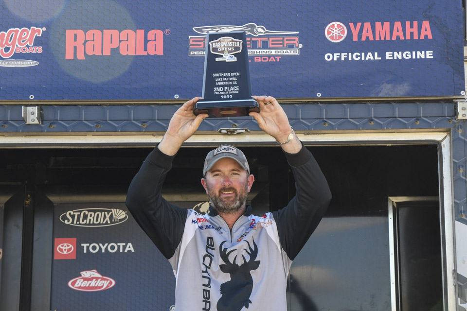 Angler Bryant Smith holds a trophy over his head.