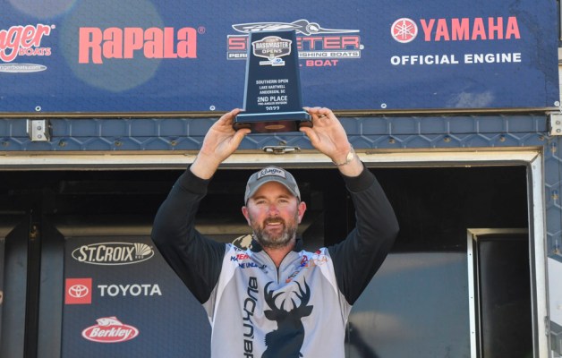 Angler Bryant Smith holds a trophy over his head.