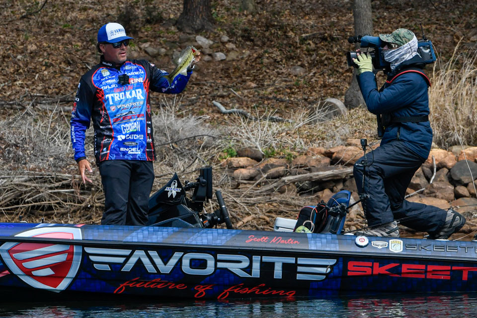 Scott Martin holds up a bass to the LIVE camera
